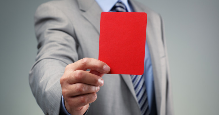 A man in a suit holding a red card