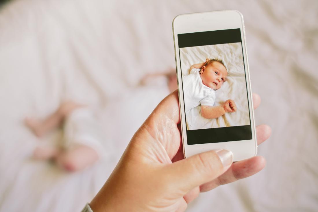 a smartphone taking a picture of a baby