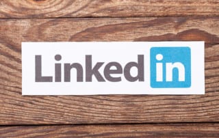 The LinkedIn logo, cut out and pasted onto a wooden background