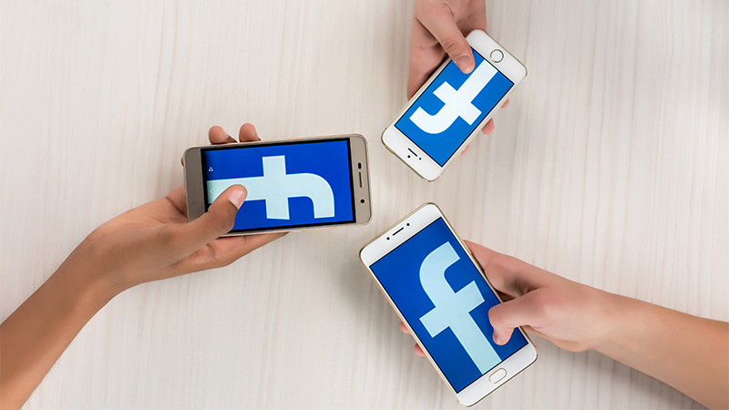 Stock photo of Facebook logo on three smart phones
