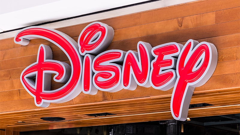 A red Disney logo on a wooden background