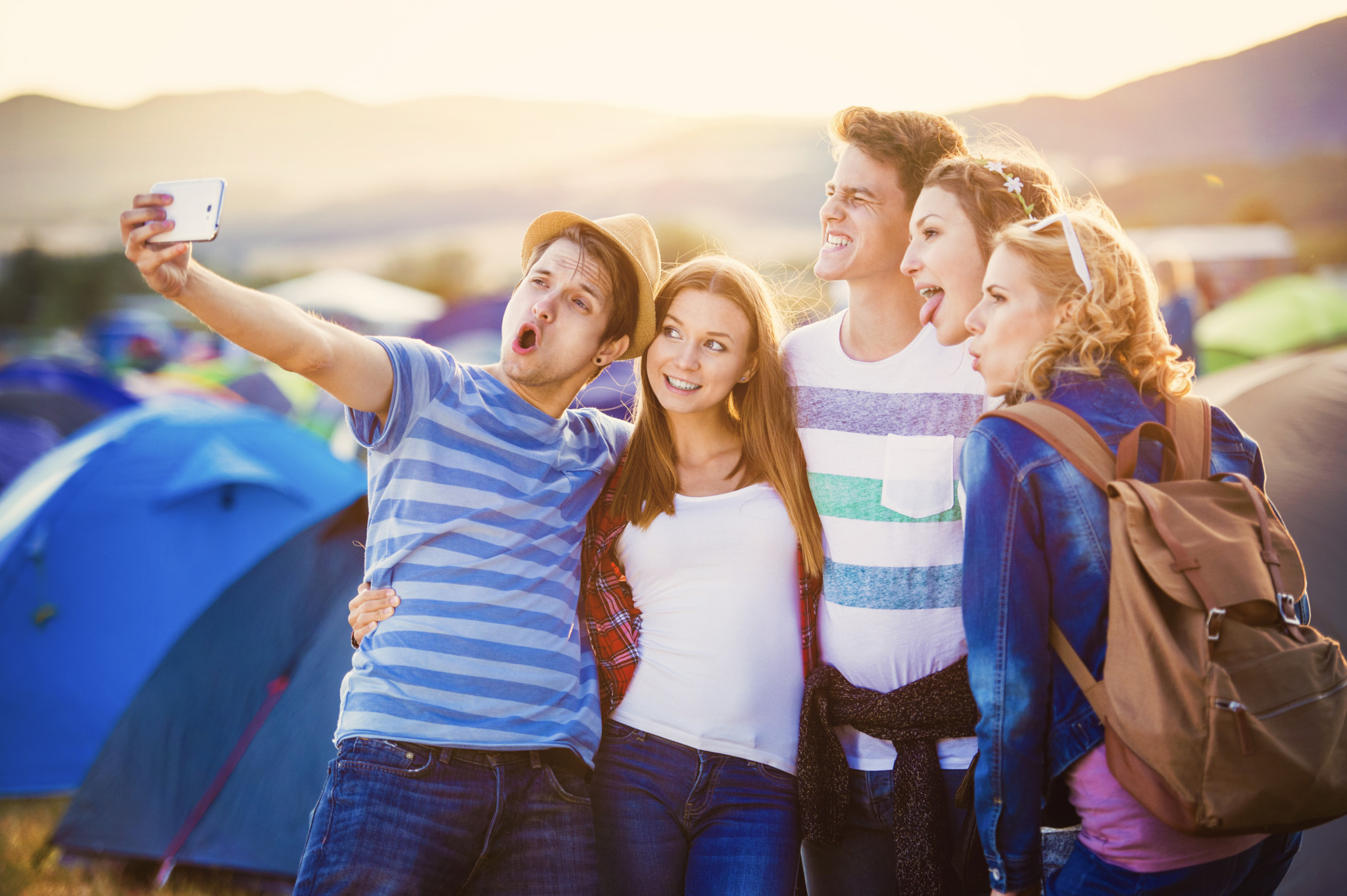 Teens at summer festival, taking a group selfie